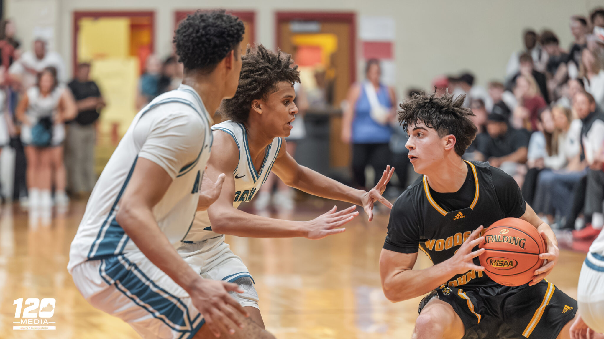 Pierre Rondo Jr. and Colin Daniels of North Oldham defending Wyatt Peters of Woodford County.